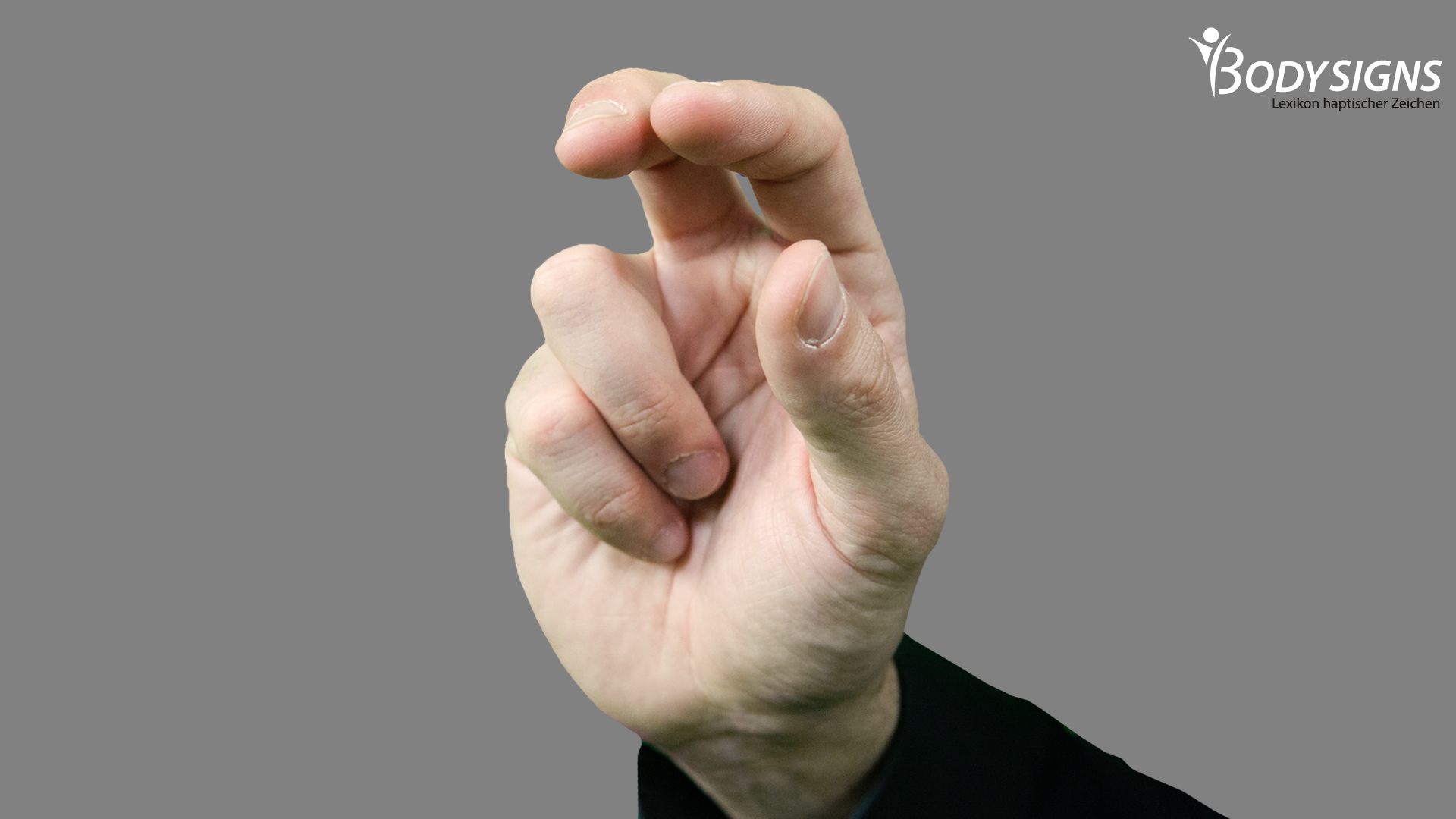 Zeige- und Mittelfinger formen mit Daumen eine lockere Greifhand, kleiner Finger und Rinfinger liegen an.