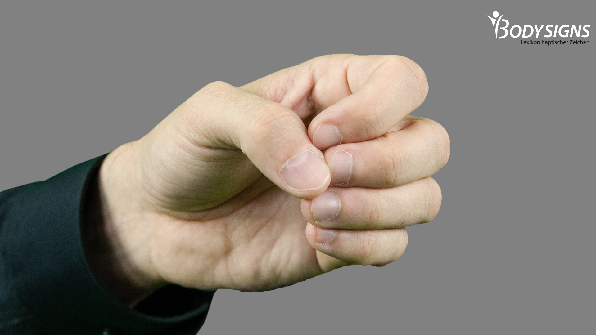 Alle Finger locker angewinkelt; die Daumenspitze liegt dabei locker auf den Spitzen von Zeige- und Mittelfinger; die Hand formt so ein O; der Handrücken zeigt nach außen 